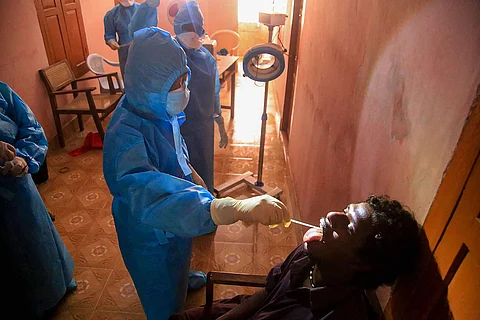 A medical professional collects swabs from a person