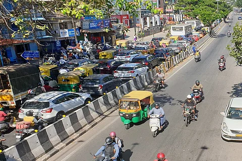 Vehicles approach the Wind Tunnel Junction on Old Airport Road at high speeds from the signal-free Suranjandas Road Junction, triggering extreme congestion.