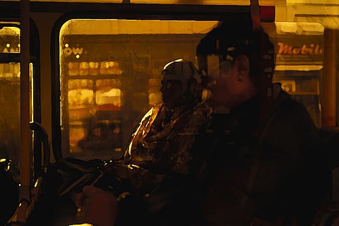 A representative picture of the silhouettes of a couple sitting inside a bus