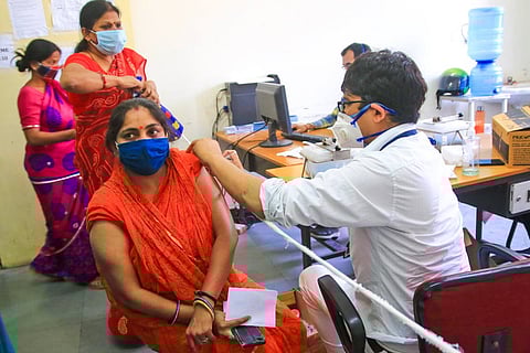A medic administers a dose of a Covid-19 vaccine to a woman