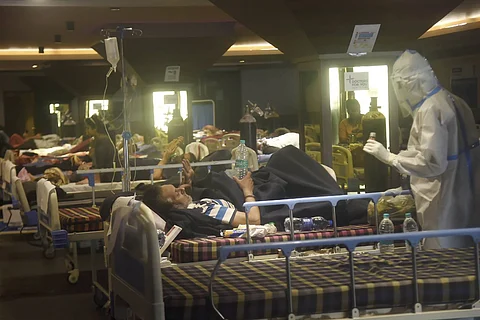 A health worker checking COVID-19 patients in a Covid ward in Delhi
