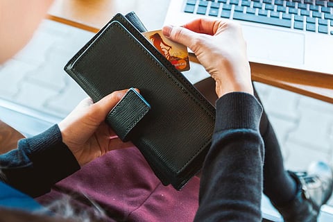 Representative image of a woman removing a credit card from her wallet