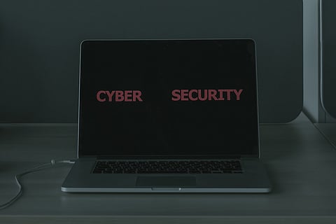 An open laptop with the words 'cyber security' on the laptop screen
