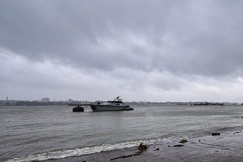A boat anchored at sea with dark clouds seen above in the sky
