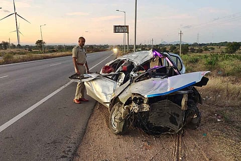 A police man standing in front of the damaged car