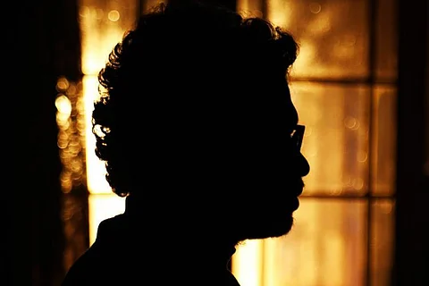 A image of a man standing in the dark.