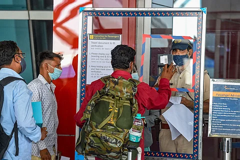 A passenger shows his passport to a security official at the Delhi airport