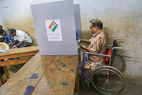 A man using a wheelchair voting at a polling booth in Tamil Nadu