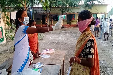 A voter getting thermal screening before exercising her franchise in Dubbaka