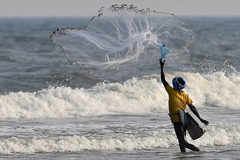 A fisherman casts his net in the sea