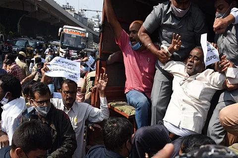 A protesting teacher being detained in a police van
