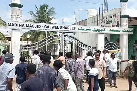 Persons gathered in front of mosque