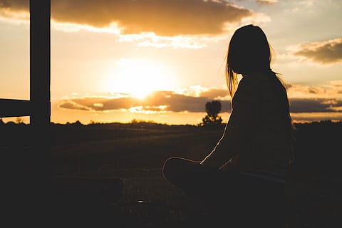 Silhouette of a young girl against the sunset