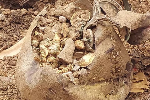 A pot containing gold ornaments