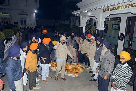 A group of man gathered around the body of a man who was beaten to death at the golden temple in Amritsar