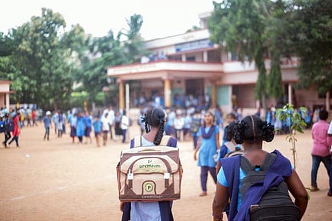 Several school students walking towards the school