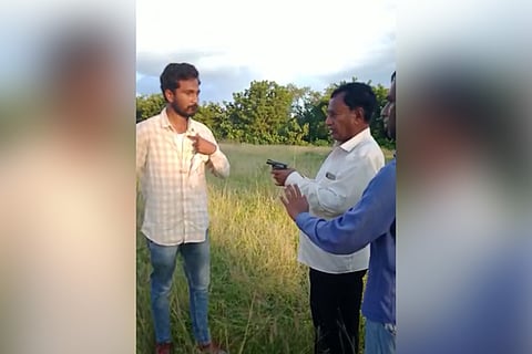 Former Minister Gutta Mohan Reddy pointing a gun at a worker