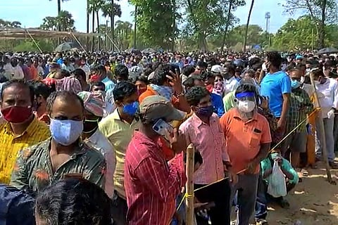 A large crowd in a serpentine queue violating physical distance