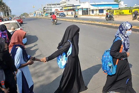 Girls wearing hijab and burqa crossing a road