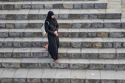 A hijab-clad woman walking alone