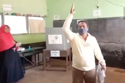 A man with his hand raised in anger after he stopped a hijab-clad woman from voting in Tamil Nadu