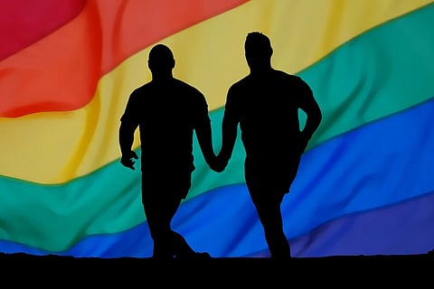 Representative image of two individuals holding hands in front of a rainbow flag: Homophobic posters related to monkeypox crop up in Alappuzha, LGBTQIA+ activists debunk them