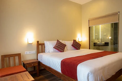 A hotel bed with white bed sheet and yellow lights