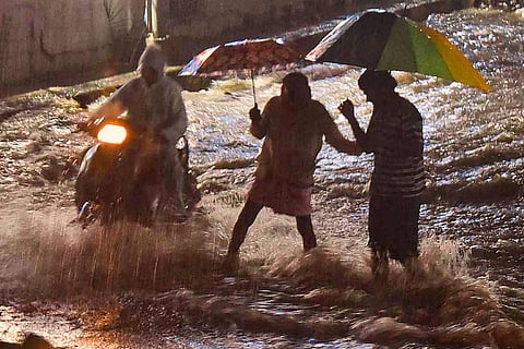 People walking down a flooded street