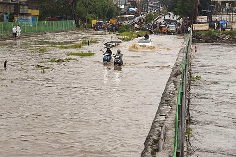 Two motorists crossing a flooded bridge