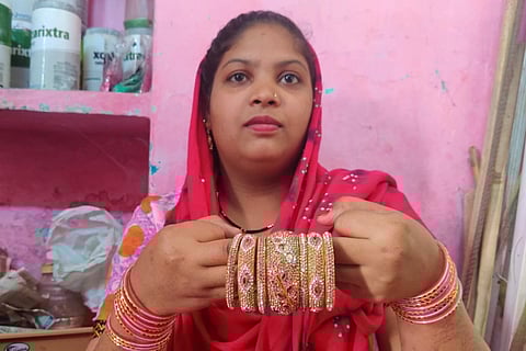 A bangle designer holding bangles