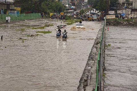 People in two wheelers cars and buses travelling in knee deep water in Hyderabad