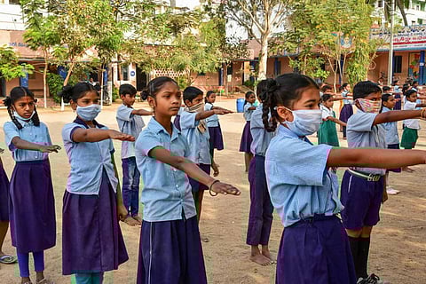A file image of students seen wearing masks as prevention against coronavirus during school assembly, in Hyderabad