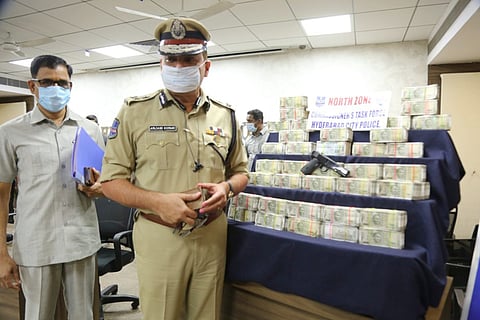 Hyderabad police commissioner posing against the seized items