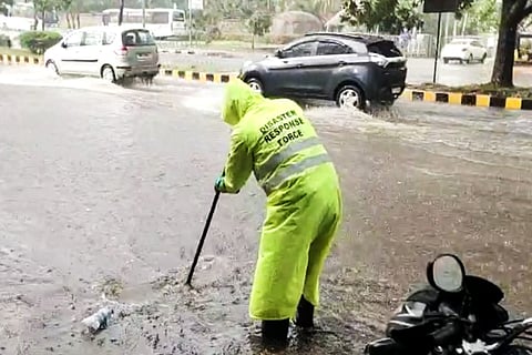 A worker from the Disaster Response Force clearing the drains