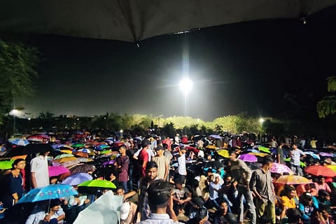 IIIT Basar students protesting in the rain holding umbrellas