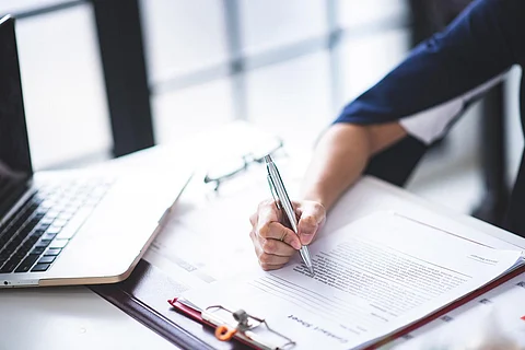 A woman filling tax documents on office desk