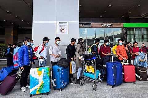 A group of Indian students who have returned from Ukraine wait with their luggage at an airport
