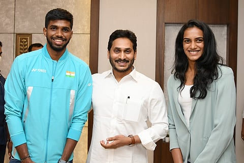 Andhra Pradesh Chief Minister Jagan Mohan Reddy with badminton players PV Sindhu to his right and Satwik Sairaj to his left