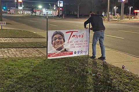 A community member installing a banner for Tanvi