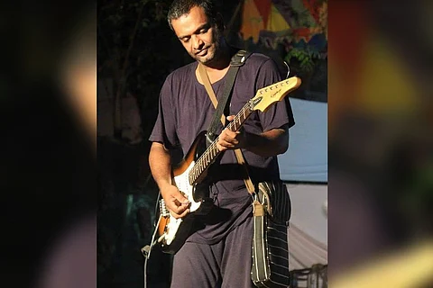 Musician John P Varkey playing a guitar