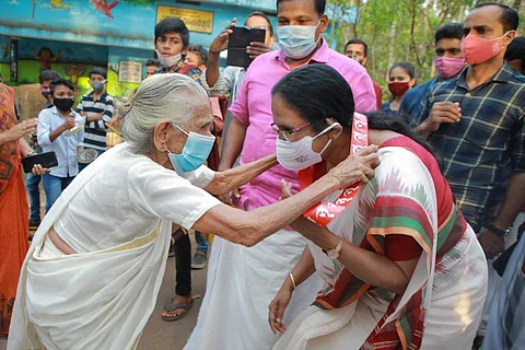A file image of KK Shailaja being garlanded by an old woman