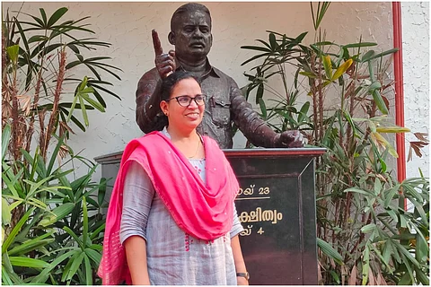 KK Rema, Kerala Assembly poll candidate from Vadakara, wearing a grey salwar and pink dupatta, standing near the statue of her slain husband TP Chandrasekharan.