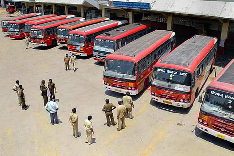 A picture from above of red color Karnataka RTC buses parked at a depot