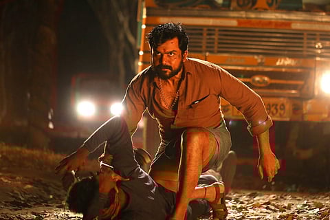 Actor Karthi in a still from 'Kaithi', hittin a man