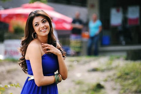 kajal in a blue dress and is seen smiling.