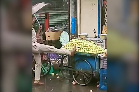 Policeman kicking a fruit cart