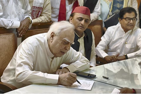 Kapil Sibal filing his nomination for a Rajya Sabha seat as SP chief Akhilesh Yadav looks on