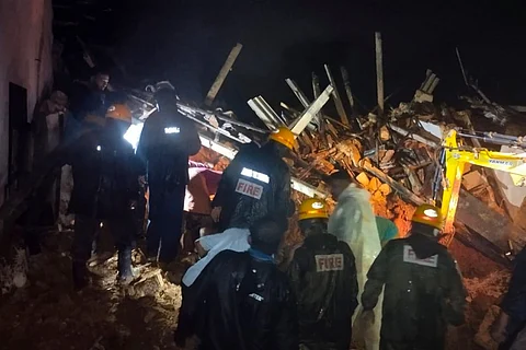 Fire and rescue officials clearing the debris following the landslide in Dakhina Kannada
