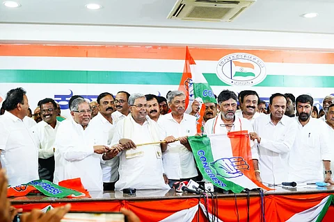 Siddaramaiah, DK Shivakumar and other Congress workers holding Congress' flag.