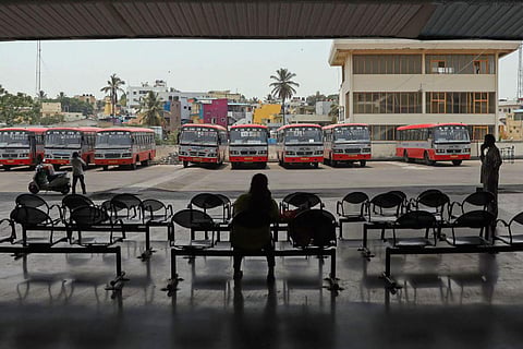 A passenger waiting at an empty bus stand in Bengaluru as bus strike continues